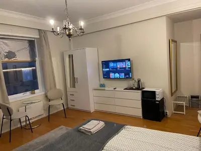 a bedroom with a bed and a flat screen tv at Kirkegata 4 in Ålesund