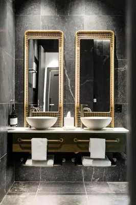 a bathroom with two sinks and two mirrors at Grande Fjord Hotel in Geiranger