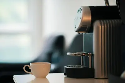 a coffee machine sitting on a table with a coffee cup at Grande Fjord Hotel in Geiranger