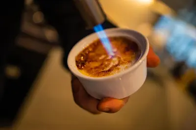 a hand holding a cup of coffee with a straw at Grande Fjord Hotel in Geiranger