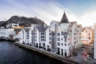 a large white building next to a body of water at Quality Hotel Ålesund in Ålesund