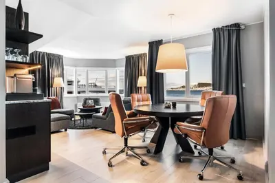 a living room with a table and chairs at Quality Hotel Ålesund in Ålesund