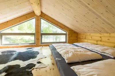 a room with two beds in a log cabin at Gladheim in Stranda