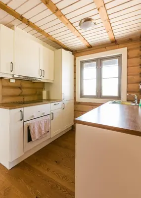 a kitchen with white cabinets and a counter top at Gladheim in Stranda