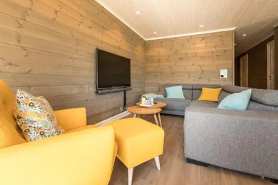 a living room with a couch and a television at Lastølen 3 bedrooms in Brunstad