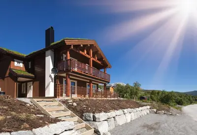 a house on the side of a road with the sun at Lastølen 3 bedrooms in Brunstad