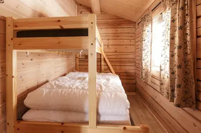 a bedroom with a bunk bed in a log cabin at Røde Kors in Brunstad