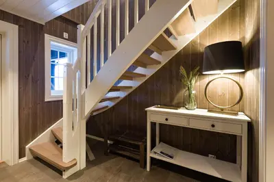 a staircase in a room with a table and a lamp at Strandafjellet Mountain Lodge in Stranda
