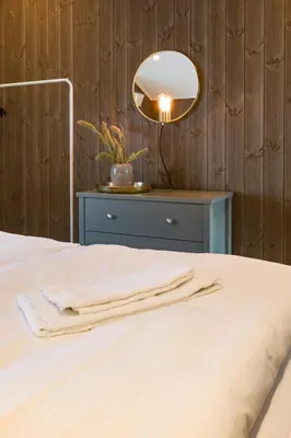 a bedroom with a bed with a lamp and a table at Strandafjellet Mountain Lodge in Stranda