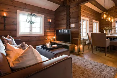a living room with a couch and a television at Strandafjellet Mountain Lodge in Stranda