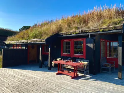 a house with a red table in front of it at Haukeli Mountain Cabin in Vågsli