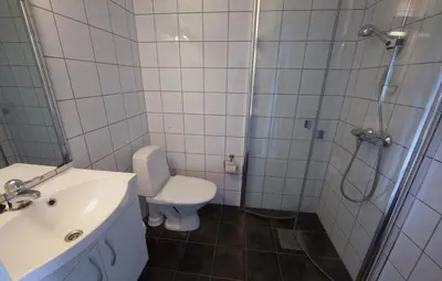 a bathroom with a shower and a toilet and a sink at Moldefjord Hostel in Molde