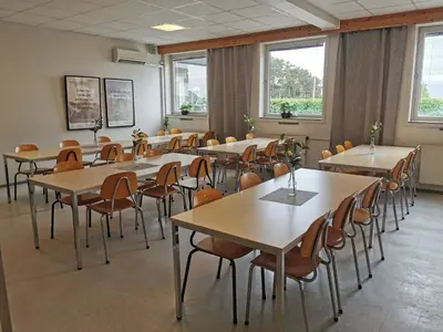 a classroom with tables and chairs and windows at Moldefjord Hostel in Molde