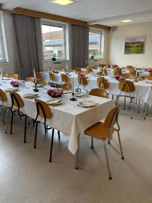a room with tables and chairs with white tablecloths at Moldefjord Hostel in Molde