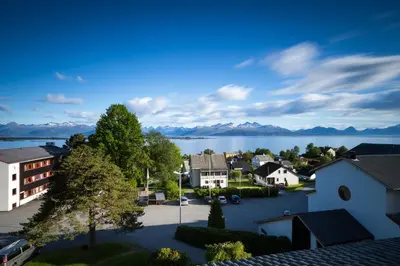 a town with a lake and mountains in the background at Moldefjord Hostel in Molde