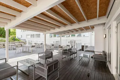 a patio with tables and chairs on a wooden deck at Kinsarvik Fjordhotel, BW Signature Collection in Kinsarvik