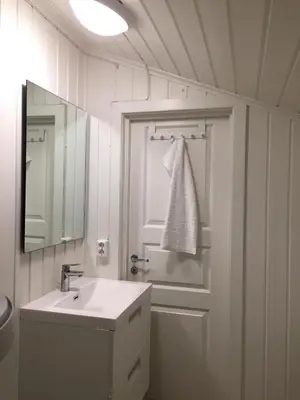 a white bathroom with a sink and a mirror at Koselig Hytte i Hemsedal with outdoor Sauna in Hemsedal