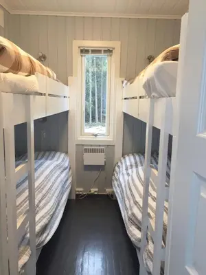 two bunk beds in a room with a window at Koselig Hytte i Hemsedal with outdoor Sauna in Hemsedal