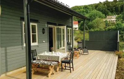 a wooden deck with a table and chairs on a house at Stunning Home In Seim With Wifi in Seim