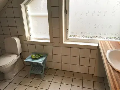 a bathroom with a toilet and a sink and a window at Lodge Visnes Stryn in Stryn