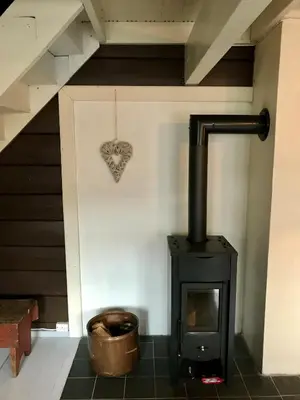 a wood stove in a room with a heart on the wall at Lodge Visnes Stryn in Stryn
