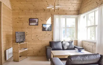 a living room with a couch and a table at Gorgeous Home In Vallavik With Wifi in Vangsbygd