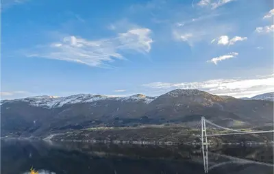 a bridge over a body of water with mountains at 3 Bedroom Pet Friendly Home In Vallavik in Vangsbygd