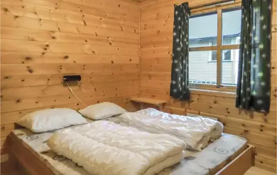 a bedroom with two beds in a wooden room at 3 Bedroom Pet Friendly Home In Vallavik in Vangsbygd