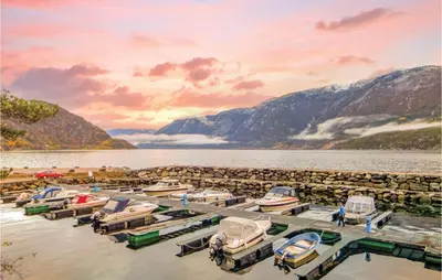 a group of boats parked in a marina on a lake at 2 Bedroom Cozy Home In Vallavik in Vangsbygd