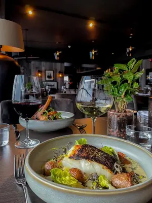 a plate of food on a table with wine glasses at Hovdestøylen in Hovden