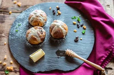 a plate with buns and a stick of butter and a stick of cheese at Venabu Fjellhotell in Venabygd