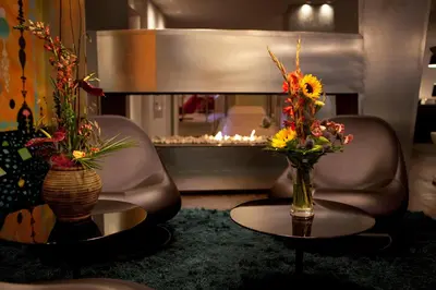 a living room with a chair and two vases with flowers at Quality Hotel Waterfront in Ålesund