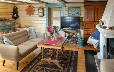 a living room with a couch and a table and a television at Three-Bedroom Holiday Home In Sjusjoen in Sjusjøen
