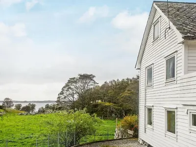 a white house with a field in the background at 8 person holiday home in FINNÅS in Vordnes