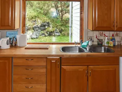 a kitchen counter with a sink and a window at 8 person holiday home in FINNÅS in Vordnes