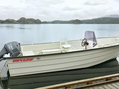 a white boat sitting on a dock on the water at 8 person holiday home in FINNÅS in Vordnes