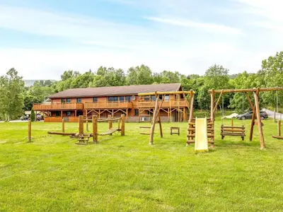 a log cabin with a playground in the grass at 5 person holiday home in EIDSVÅG in Eidsvåg