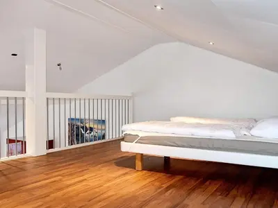 a white bedroom with a bed and a wooden floor at 6 person holiday home in EIDSVÅG in Eidsvåg