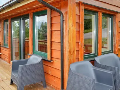a cabin with windows and chairs on a deck at 6 person holiday home in EIDSVÅG in Eidsvåg