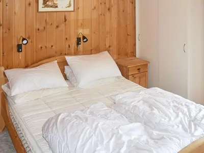 a white bed in a room with a wooden wall at 4 person holiday home in Måndalen in Sæbø