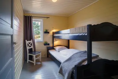 a bedroom with two bunk beds and a window at Hustadvika Havhotell - by Classic Norway Hotels in Farstad