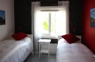 two beds in a room with a window at Nordbø Pensjonat in Hjartdal
