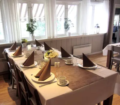 a long table with white tablecloths and napkins on it at Nordbø Pensjonat in Hjartdal