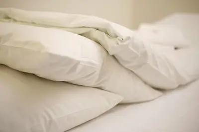 a pile of white pillows on a bed at Førde Sommarhotell in Førde