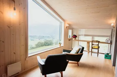 a room with two chairs and a large window at Ein heilt spesiell låve i Røldal in Røldal