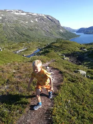 a young boy walking on a hill near a body of water at Ein heilt spesiell låve i Røldal in Røldal