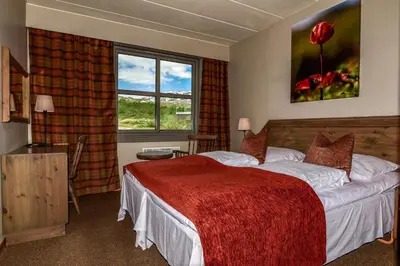 a hotel room with a bed and a window at Grotli Høyfjellshotell in Grotli