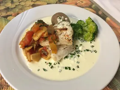 a white plate of food with vegetables and meat at Sødorp Gjestgivergård Motell in Vinstra