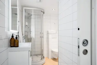 a white bathroom with a shower and a sink at Private House & Bungalow by the sea in Trondheim