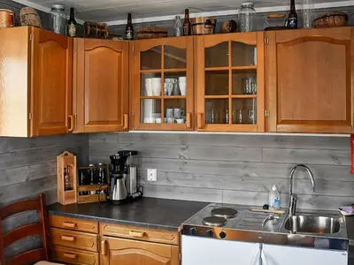a kitchen with wooden cabinets and a counter top at 8 person holiday home in Urangsvåg-By Traum in Ervik